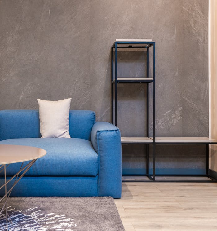 Cozy sofa and empty bookshelf in modern apartment